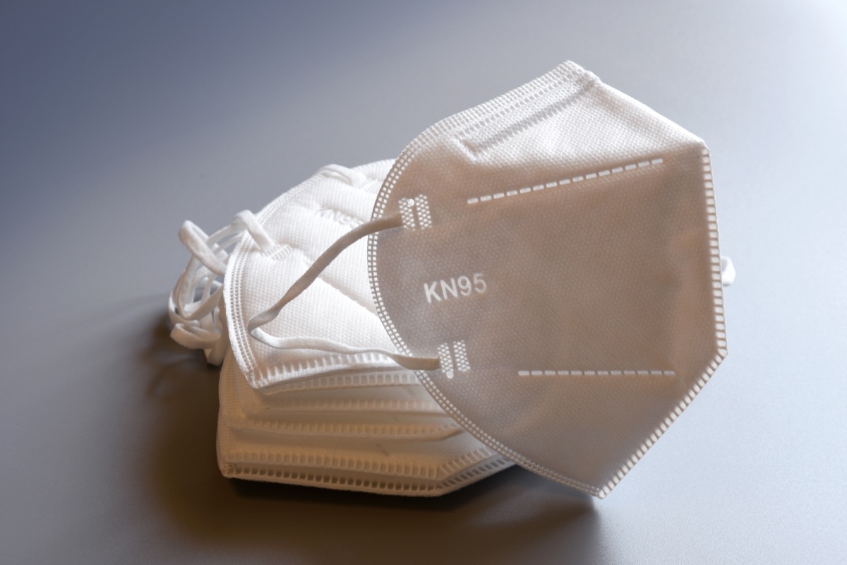 white KN95 or N95 mask for protection pm 2.5 and corona virus isolated on grey background. Prevention of the spread of virus and pandemic COVID-19.