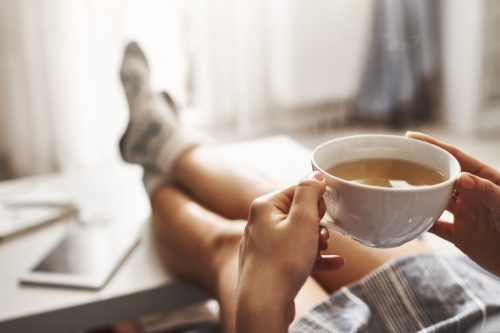 Woman drinking tea with feet up