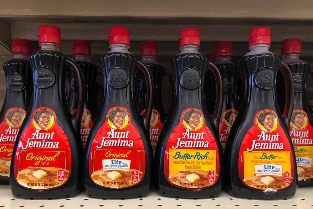 Bottles of Aunt Jemima maple syrup sitting on a store shelf