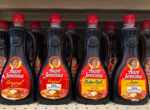 Bottles of Aunt Jemima maple syrup sitting on a store shelf