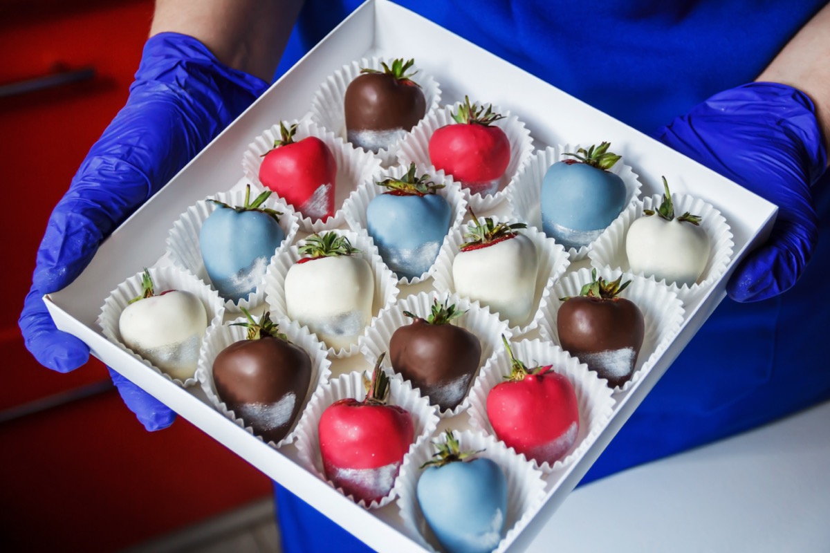 woman holding a box of chocolate covered strawberries