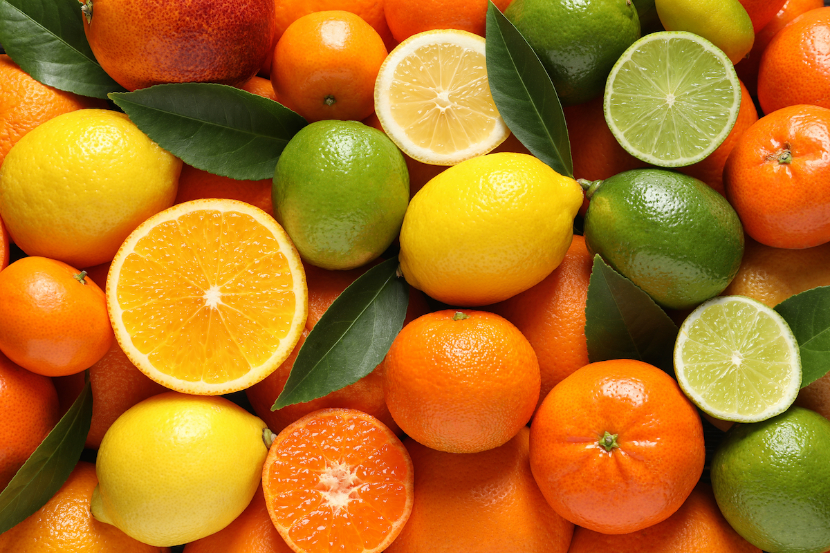 Different citrus fruits with leaves as background