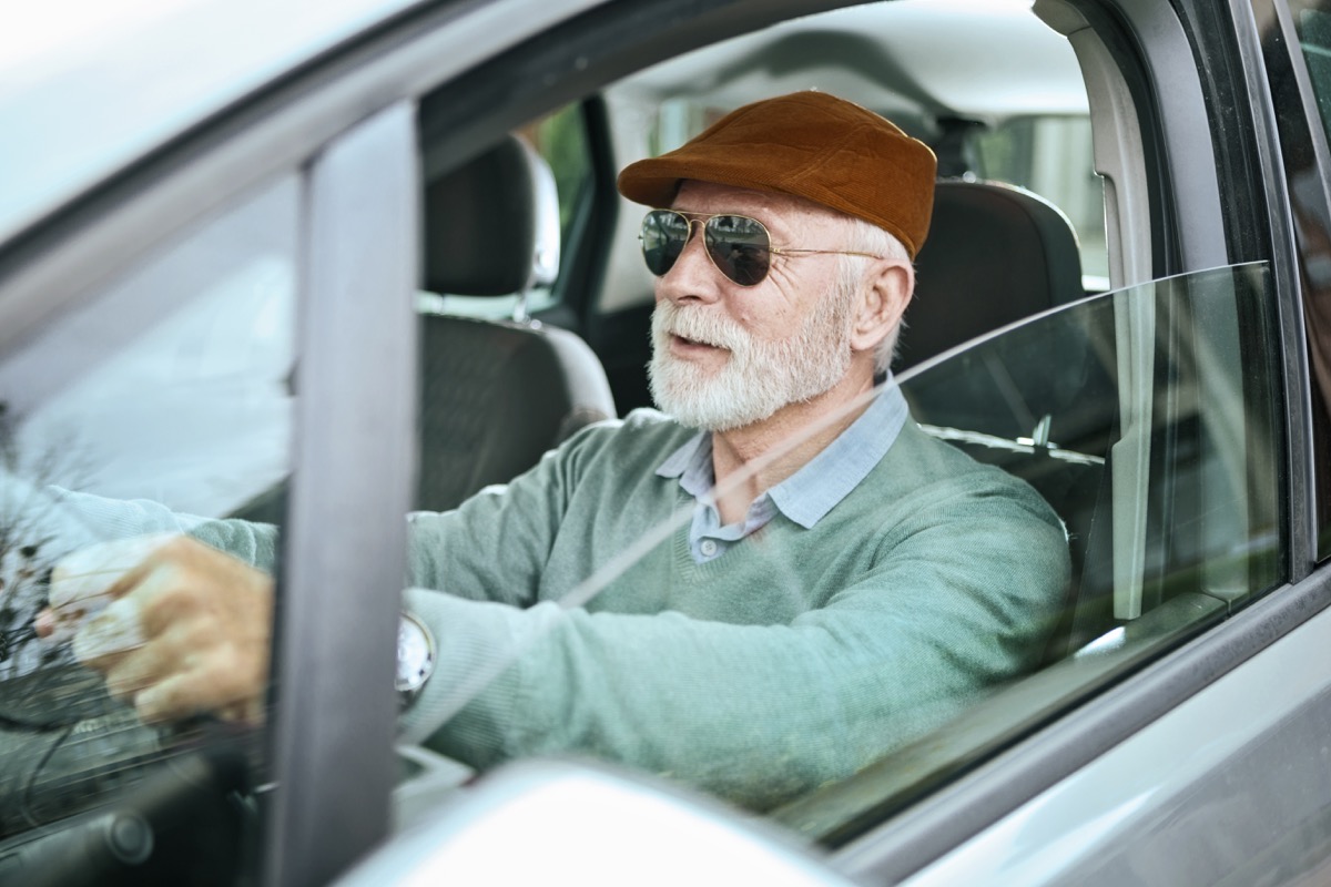 Senior man sitting in car driving