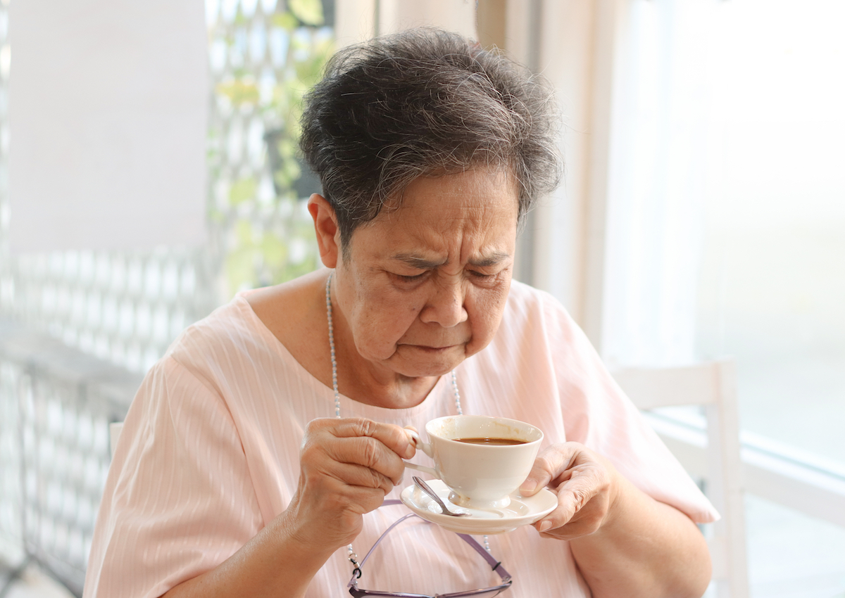 Senior woman tasting bitter coffee