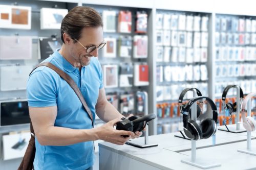 man buying headphones in electronics store