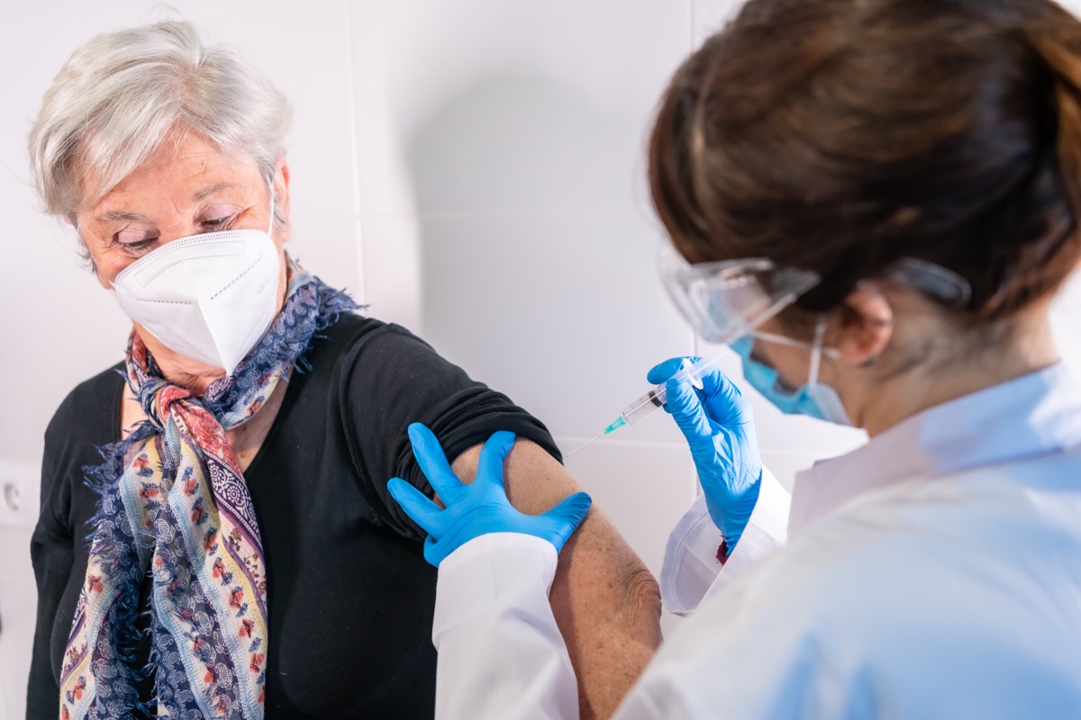 woman with gray hair getting COVID vaccine