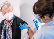 woman with gray hair getting COVID vaccine