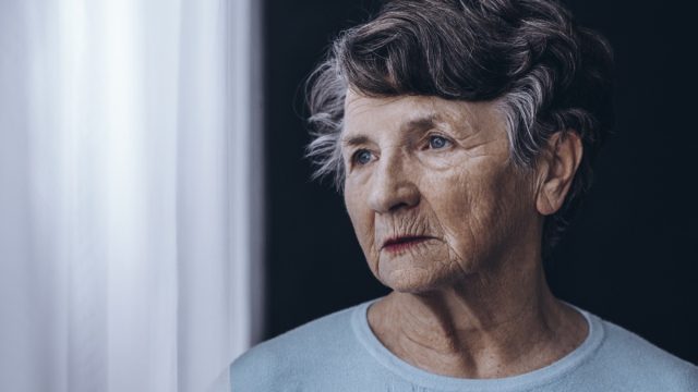 Older woman looking out window