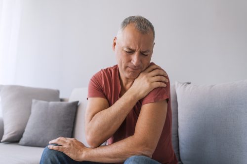 Photo of mature man suffering from pain in arm