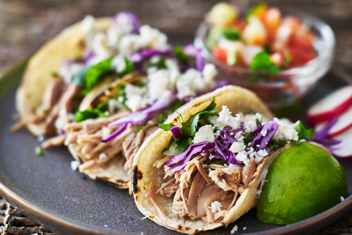 Street tacos with carnitas, red cabbage and queso fresco cheese
