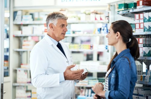 Shot of a mature pharmacist assisting a young woman in a chemist