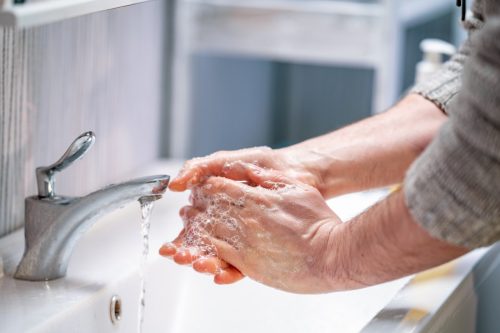 person washing hands at sink