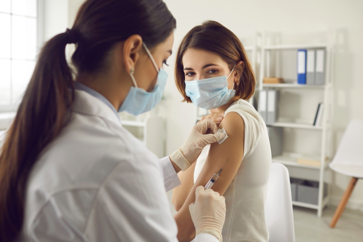 woman getting covid vaccine wearing a surgical mask