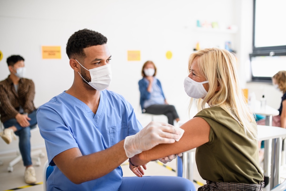 young doctor giving middle-aged woman a covid vaccine