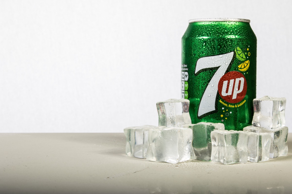 A can of 7up with ice against it