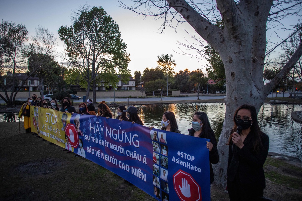 People hold a banner during a candlelight vigil