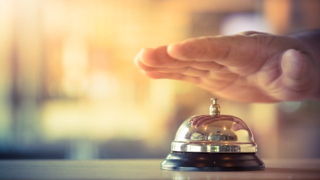Hand over bell at hotel reception