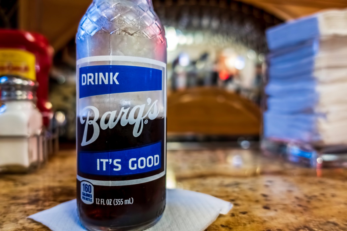 A glass bottle of Barq's root beer on a counter