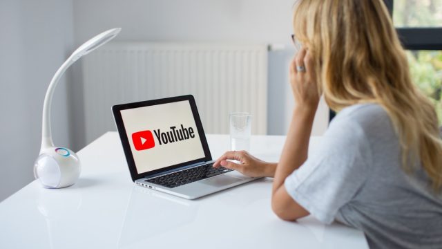 blonde woman watching youtube on computer