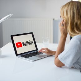 blonde woman watching youtube on computer