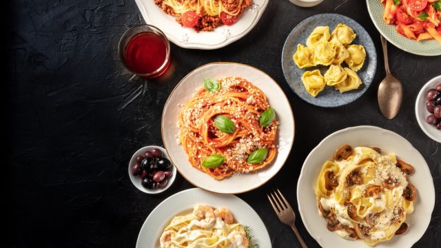 bowls of different kinds of pasta on black table