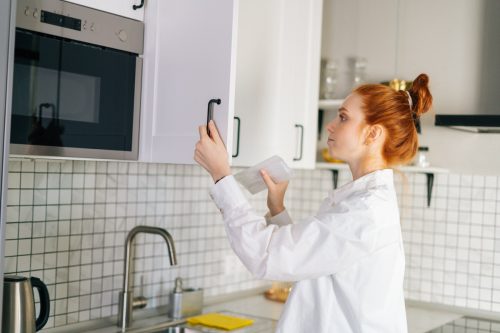 Woman looking in kitchen cabinet