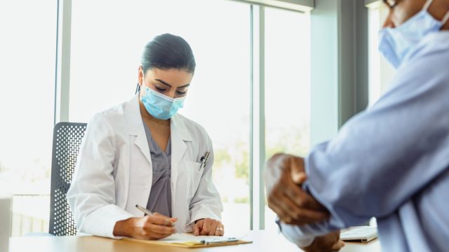 Doctor takes notes during medical appointment