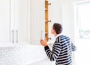 Man looking in kitchen cabinet