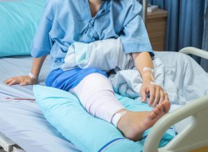lderly old woman patient lying with bandage compression knee brace support injury on the bed in nursing ward hospital.