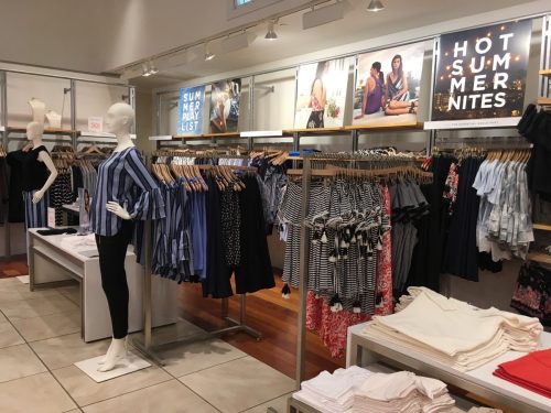 interior of loft clothing store with mannequins and clothes on racks