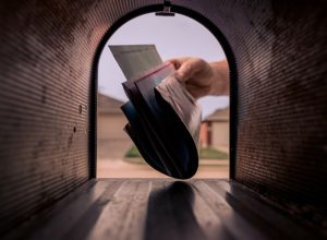 A hand removing mail from the mailbox.