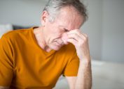 Portrait of senior man suffering from migraine or stroke