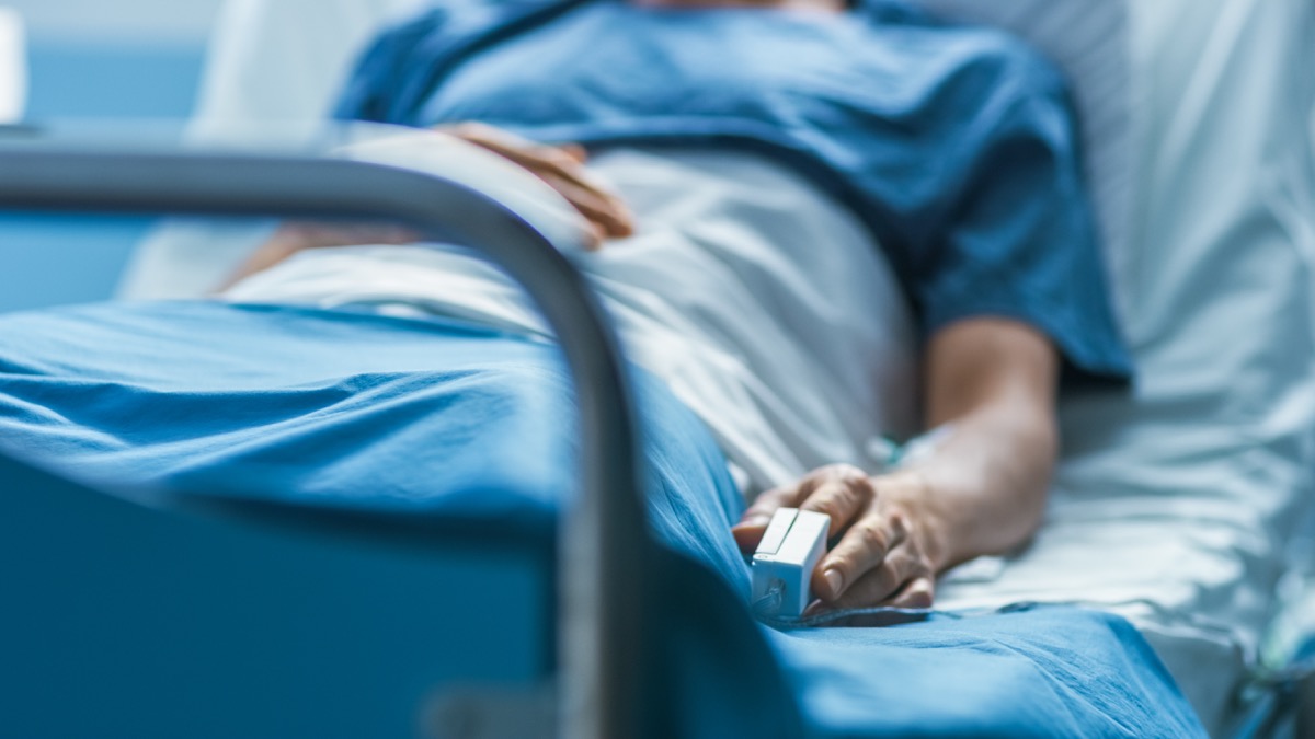 Im Krankenhaus schläft ein kranker Mann auf dem Bett.  Finger-Herzfrequenzmesser.