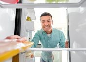 middle-aged man taking meat out of the fridge