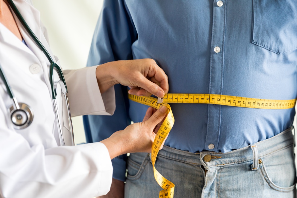 man getting measured after losing some weight