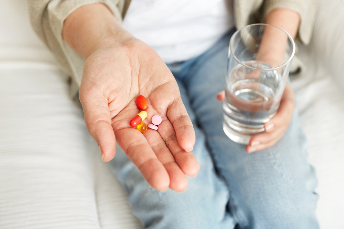 Woman taking pills with water