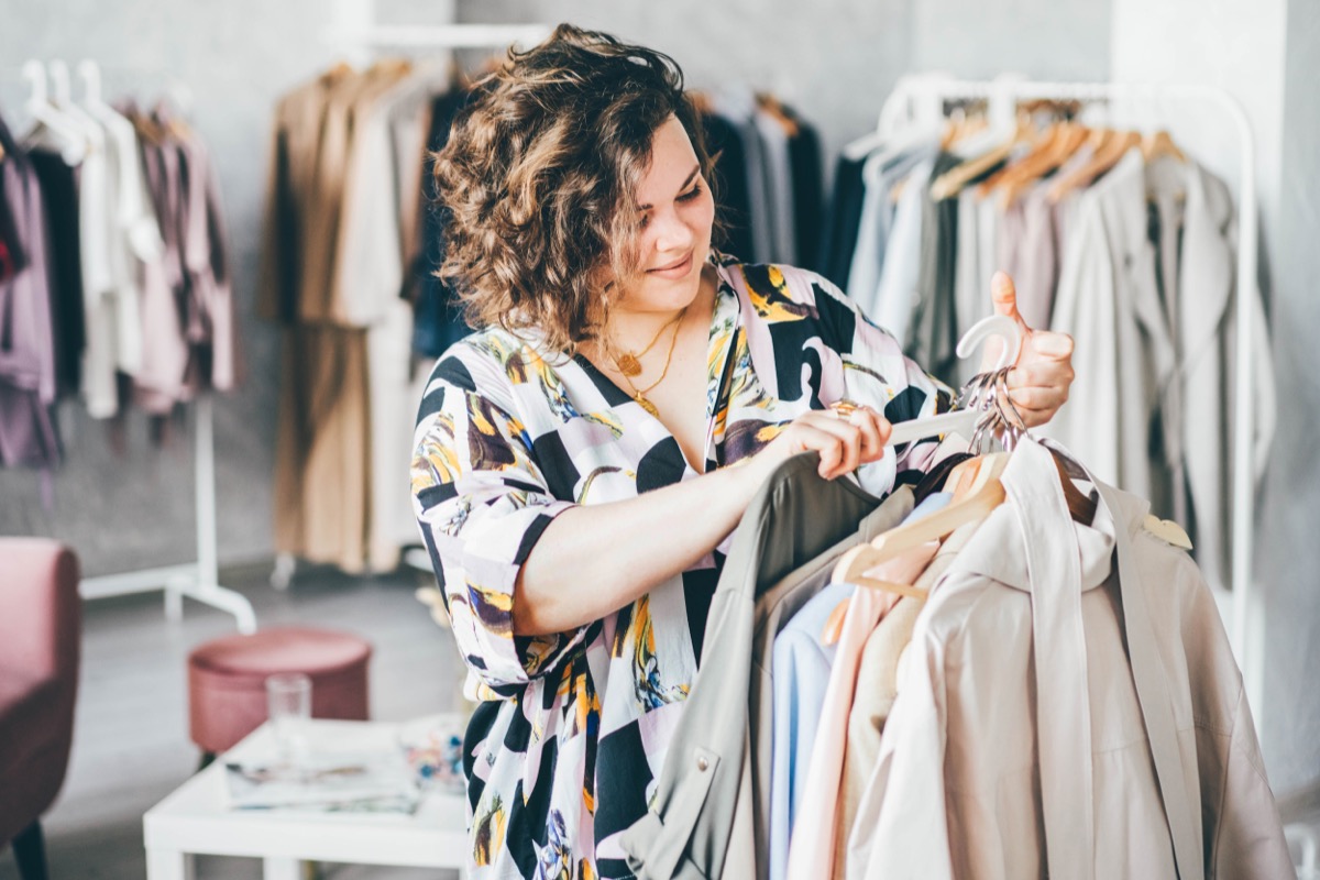 plus size woman with curly hair shopping for clothing