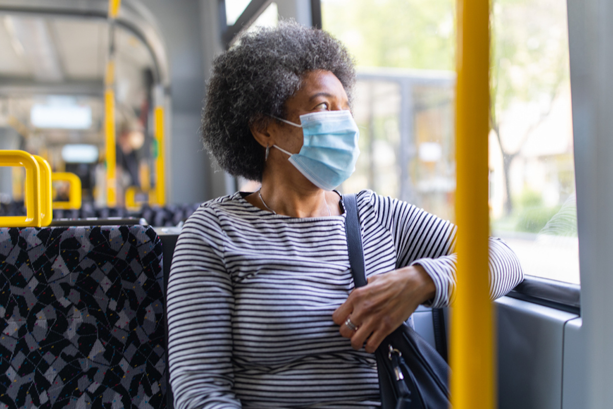 Woman wearing medical face mask commuting in during coronavirus outbreak