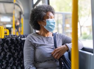 Woman wearing medical face mask commuting in during coronavirus outbreak