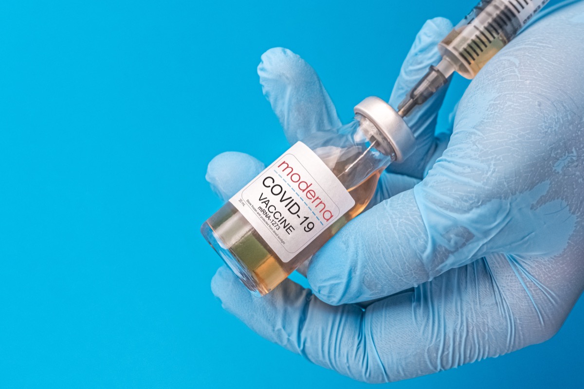 moderna covid vaccine, blue background, blue glove
