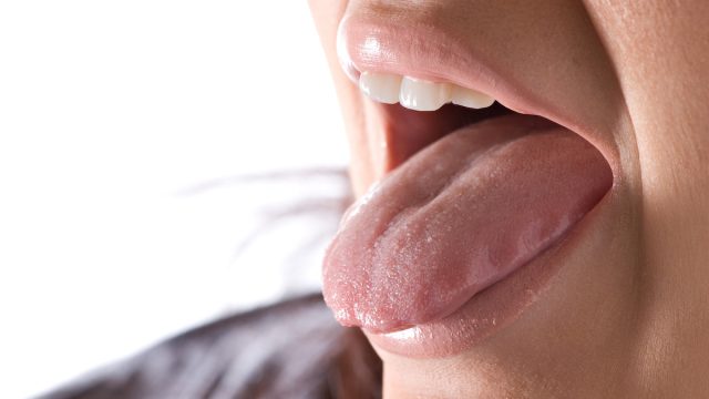 Closeup of a young woman sticking out her tongue.
