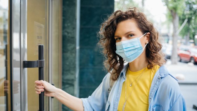 woman in yellow shirt wearing surgical mask