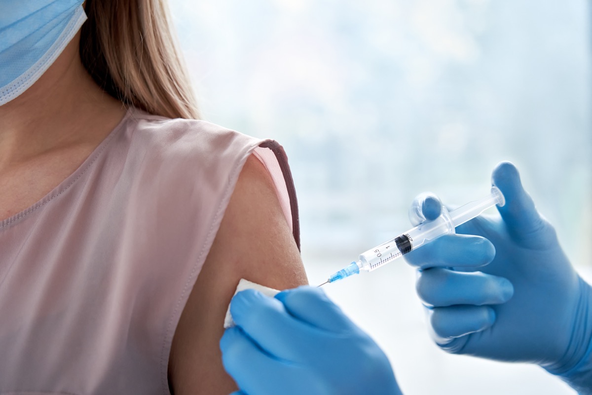woman getting vaccinated, blue gloves, vaccination