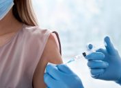 woman getting vaccinated, blue gloves, vaccination