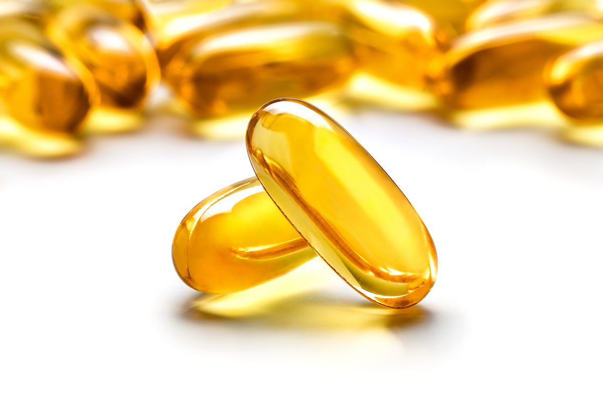 vitamin E supplements on white background