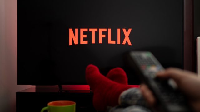person in red socks watching netflix on tv