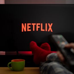 person in red socks watching netflix on tv