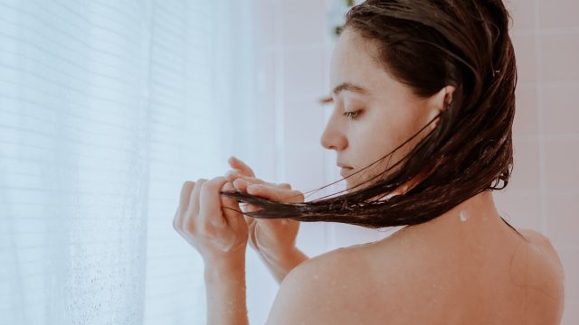Woman taking a shower and washing her hair at home