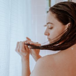 Woman taking a shower and washing her hair at home