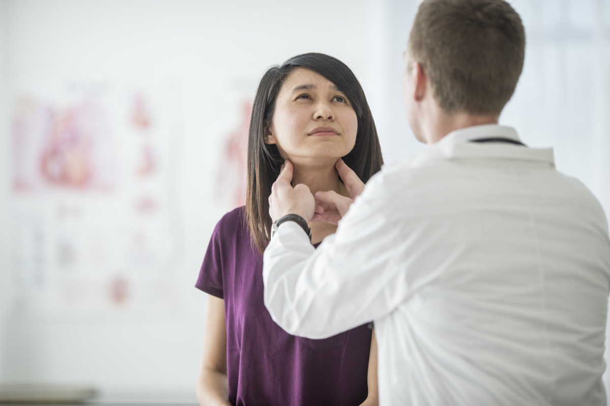 A woman is at the doctor's office for a visit to her doctor. She is getting a medical examination and advice for her health. Here she receives a thyroid examination for a cancer check.